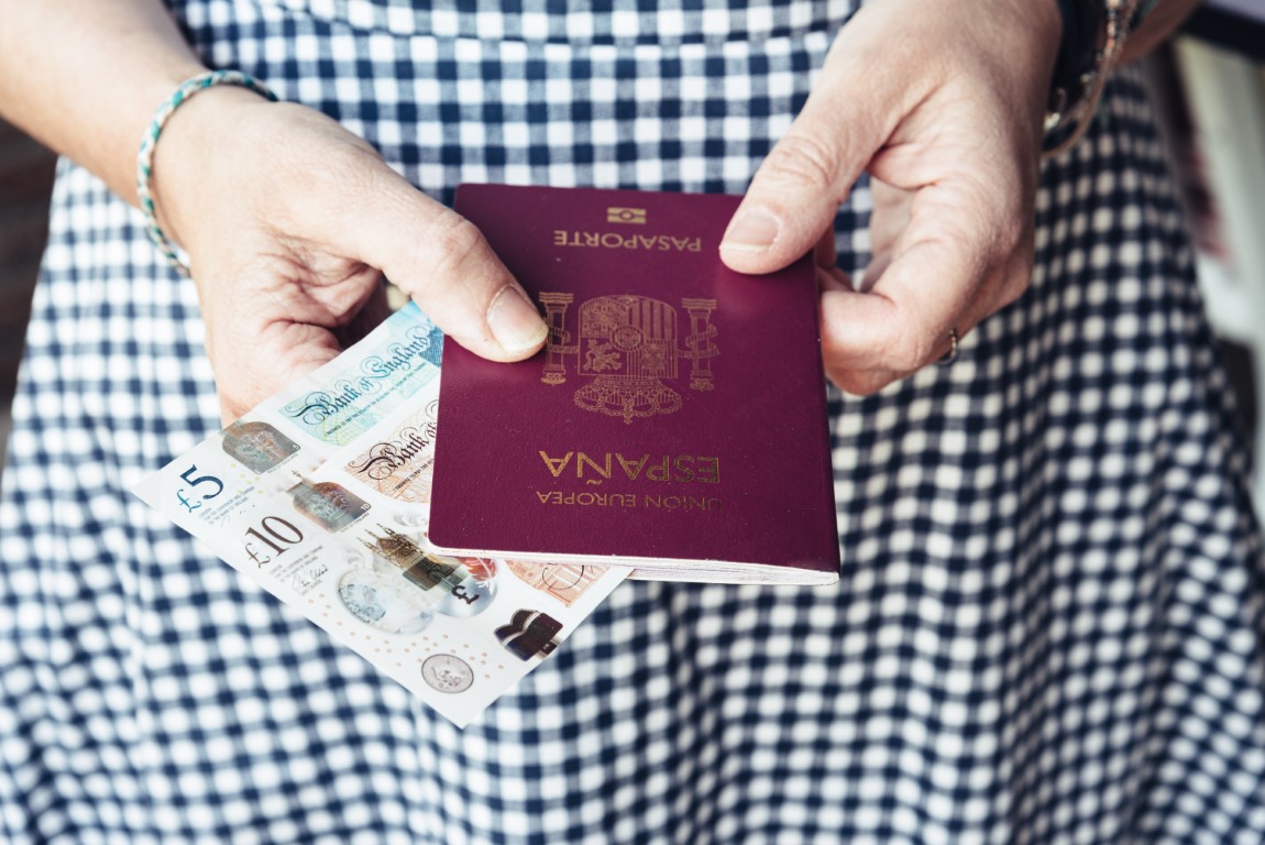 Close up of woman with passport and banknotes.